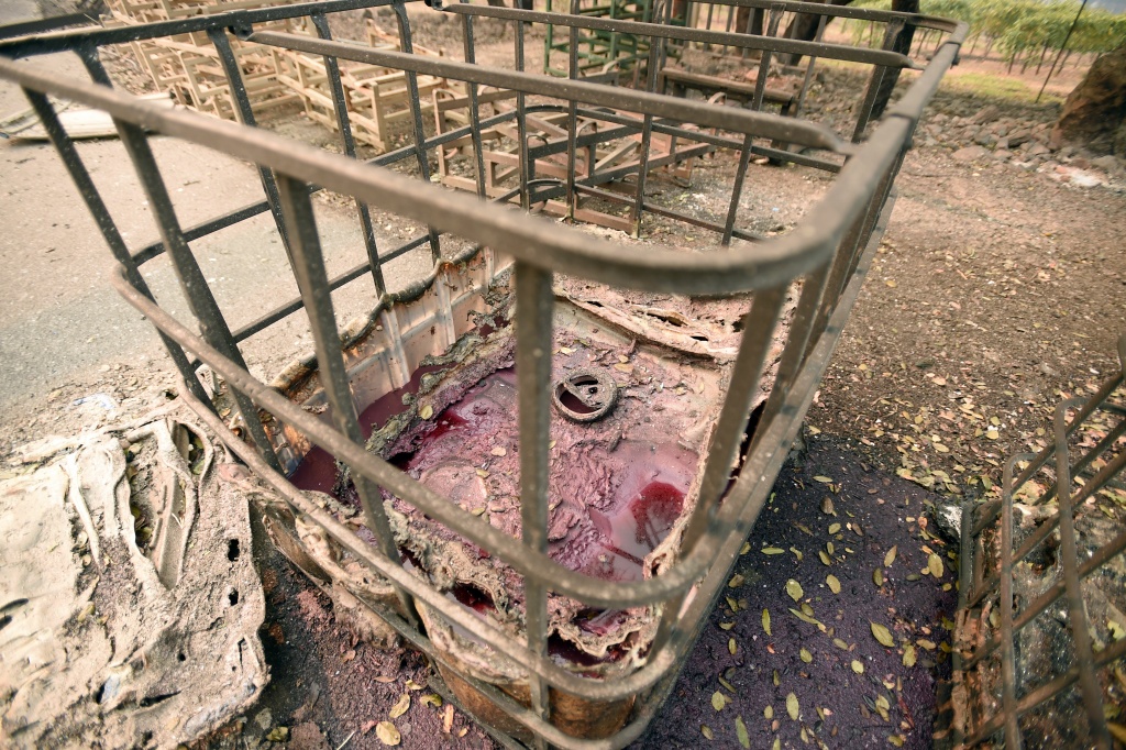 US-FIRE-CALIFORNIA A melted wine container leaks wine into the ground at the burned remains of the Paradise Ridge Winery in Santa Rosa, California on October 10, 2017.