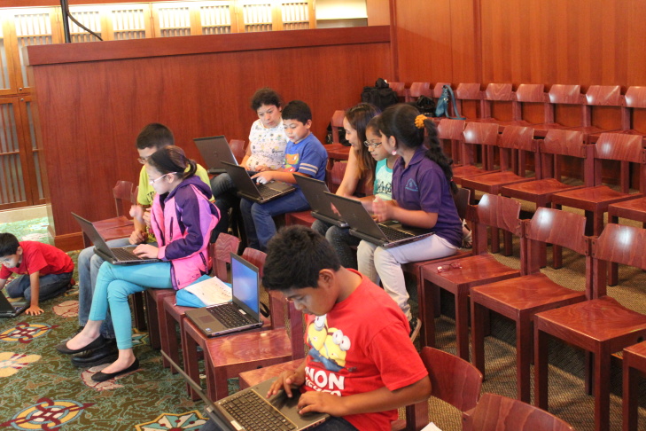 Children’s librarian Brooke Sheets (center) uses colored cups to teach algorithms and debugging to a group of girls at a computer science fair at L.A.'s downtown Central Library