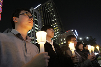 South Koreans take a moment of silence for South Korean marines killed in a North Korean bombardment during a rally against North Korea's attack onto South Korean island, in Seoul, South Korea, Tuesday, Nov. 23, 2010. North Korea shot dozens of rounds of artillery onto a populated South Korean island near their disputed western border Tuesday, military officials said, setting buildings on fire and prompting South Korea to return fire and scramble fighter jets.