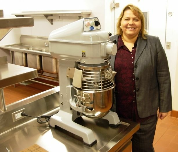 Mercer 12660 Downtown Women's Center CEO Lisa Watson witha new commercial mixer, donated by the Rotary Club, in the DWC's huge new facility, which includes a giant new kitchen, which doubles as job training center for the women who rely on the center for a dignified life.