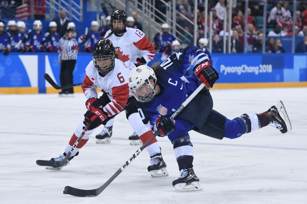 IHOCKEY-OLY-2018-PYEONGCHANG-USA-CAN USA's Meghan Duggan (front) controls the puck in front of Canada's Rebecca Johnston in overtime in the women's gold medal ice hockey match between the US and Canada during the Pyeongchang 2018 Winter Olympic Games on February 22, 2018.