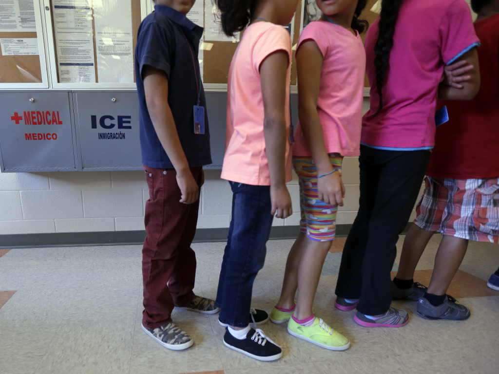 Detained immigrant children line up in the cafeteria at a temporary home for immigrant women and children detained at the border, in Karnes City, Texas. Detained immigrant children line up in the cafeteria at a temporary home for immigrant women and children detained at the border, in Karnes City, Texas.