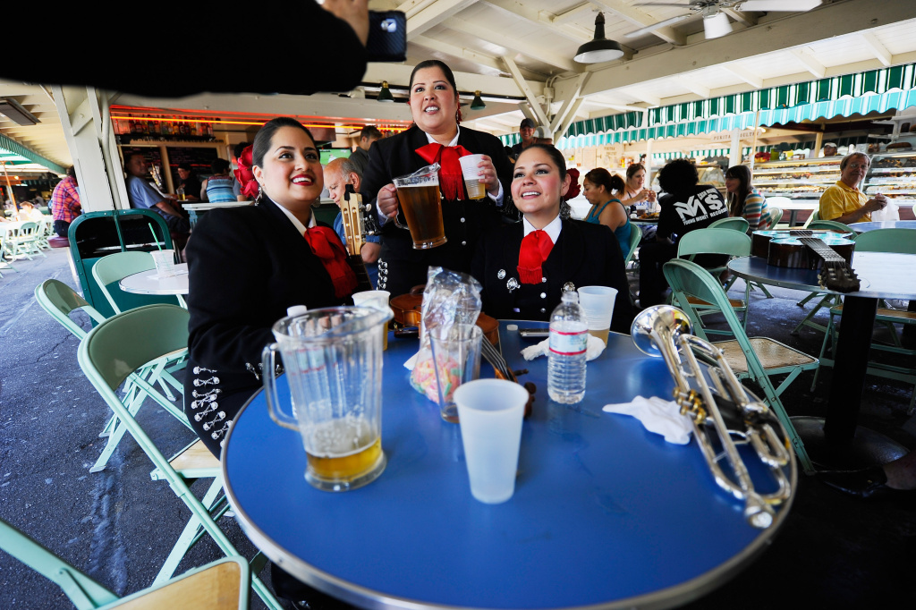 Cinco De Mayo Celebrated In Los Angeles Mariana Nanez (L) Esmeralda Garcia (C) and Judith Merillo members of the all-female strolling Mariachi band Ellas Son rest between performances for some beer at the Los Angeles Farmer Market during Cinco de Mayo festivities on May 5, 2011, in L.A.