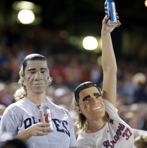 Fans wear President Obama and Mitt Romney masks at the Atlanta Braves-Miami Marlins game Sept. 25 in Atlanta. One of many quirky election year predictors is based on which candidate's likeness sells better as a Halloween mask.
