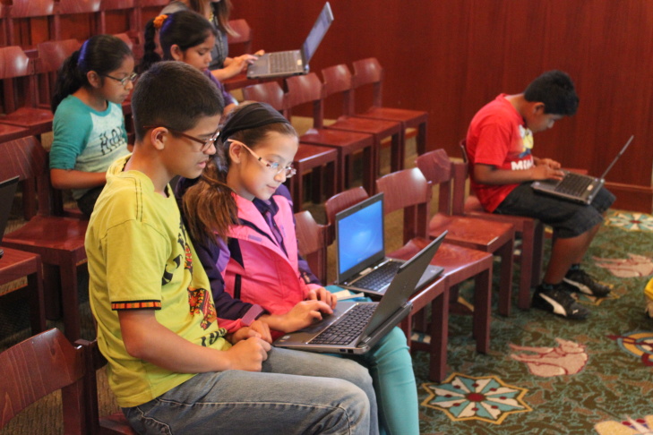 Children’s librarian Brooke Sheets (center) uses colored cups to teach algorithms and debugging to a group of girls at a computer science fair at L.A.'s downtown Central Library
