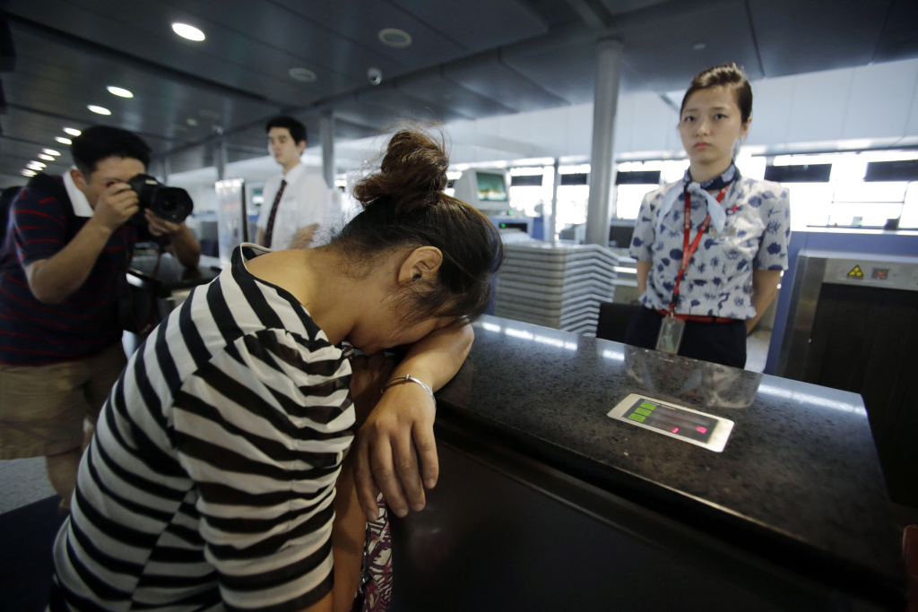 APTOPIX China US San Francisco Airliner Crash An unidentified family member of one of two Chinese students killed in a crash of Asiana Airlines' plane on Saturday, cries at the Airlines' counter as she and other family members check in a flight to San Francisco at Pudong International Airport in Shanghai, China, Monday, July 8, 2013. The Asiana flight crashed upon landing Saturday, July 6, at San Francisco International Airport, and the two of the 307 passengers aboard were killed. (AP Photo/Eugene Hoshiko)