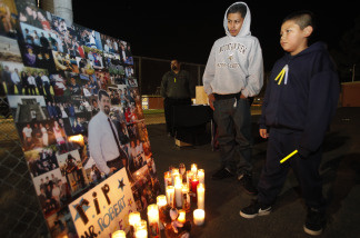 Students Aldo Vazquez, 17, left, and Juan Guerero, 10, right, pause next to a photo of late Augustin Roberto 'Bobby' Salcedo, during candle light vigil at Mountain View High School in El Monte, Calif., Monday, Jan. 4, 2010. Augustin Roberto 'Bobby' Salcedo, an assistant principal at El Monte High School was murdered in Gomez Palacio, Mexico, Dec. 30, 2009. Salcedo and his wife were there for the holidays visiting family members.