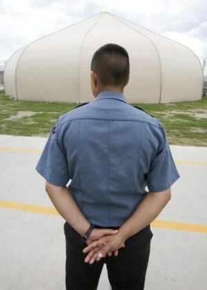 A guard stands outside one of the tent-like structures at the Willacy Detention Center in Texas, May 2007