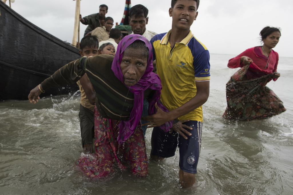 Rohingya Refugees Flood Into Bangladesh A young Rohingya man helps an elderly woman out of the sea after the wooden boat they were traveling on from Myanmar crashed into the shore and tipped everyone out on September 12, 2017 in Dakhinpara, Bangladesh.