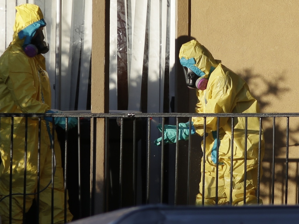 Hazardous material cleaners disinfectant their personal protective equipment after working in the apartment where Thomas Eric Duncan, the Ebola patient who traveled from Liberia to Dallas, had been staying. Hazardous material cleaners disinfectant their personal protective equipment after working in the apartment where Thomas Eric Duncan, the Ebola patient who traveled from Liberia to Dallas, had been staying.