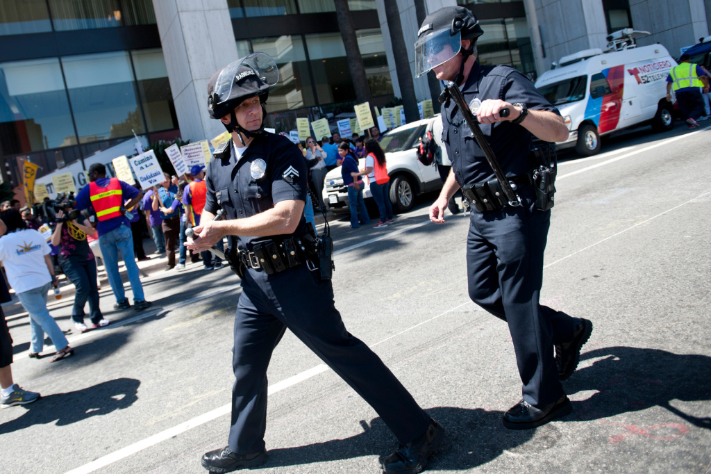 LA Immigration March - 9 LAPD put on helmets, and take a stance around an immigration march.