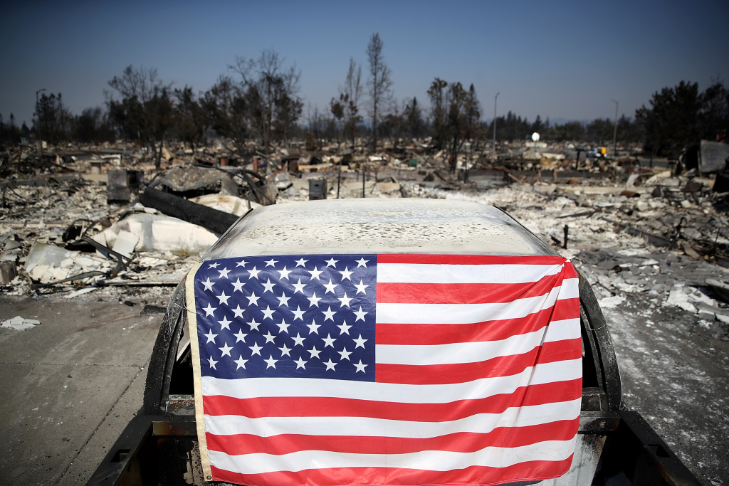 Multiple Wildfires Continue To Ravage California Wine Country An American flag hangs on a car in front of homes that were destroyed by the Tubbs Fire on October 12, 2017 in Santa Rosa, California.