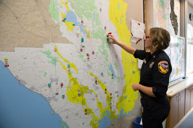 RS28986_dispatch7-qut-800x533.jpg Cal Fire Capt. Leah Simmons-Davis moves magnets on a map representing firefighters. On the night of Oct. 8, Cal Fire staff ran out of magnets for fires, so crews had to start using Post-its.