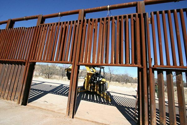 Broken Borders Fronteras Workers raised the gate on the border fence of the U.S.-Mexico boundary to clean away debris from a cross-border wash. Accumulated debris has knocked down fence segments in the past.