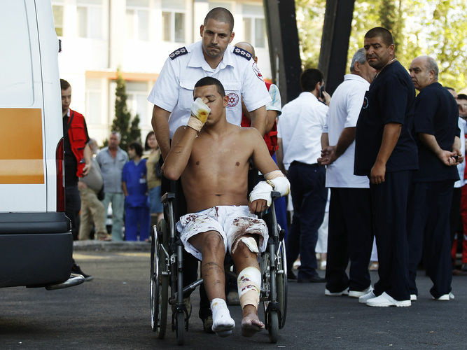 An Israeli survivor is carried on a wheelchair to an ambulance as he leaves a hospital in Burgas, Bulgaria on July 19. A suicide bomb attacker killed eight people in a bus transporting Israeli tourists at a Bulgarian airport, the country's interior minister said, and Israel pointed its finger at Iranian-backed Hezbollah militants.
