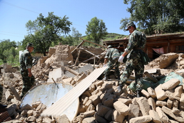 CHINA-QUAKE Rescuers rushed to find victims buried by twin shallow earthquakes in northwest China Monday after the double tremors killed at least 75 people and injured almost 600, officials said. (Photo: Rescuers search for survivors in the ruins of a damaged house in Hetuo township in Dingxi, northwest China's Gansu province on July 22, 2013).