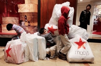 Children wait with shopping bags inside Macy's department store on 'Black Friday,' Nov. 26, 2010 in New York City.