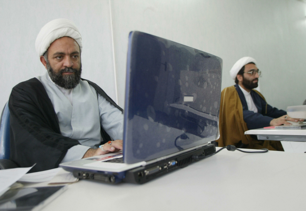 Iranian on computer Iranian Nematollah Daneshmand (L), works on his laptop at his office in Qom, south of Tehran.