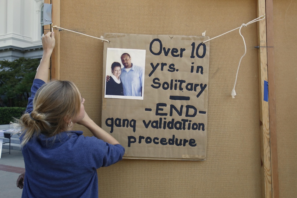 California Prisons Solitary Georgia Valentine, an intern with the legal Services for Prisoners with Children, hangs a poster calling for the reform in the use of solitary confinement in California prisons during a demonstration at the Capitol in Sacramento, Calif., Wednesday, Oct. 9, 2013. Members of the Assembly and Senate public safety committees held the first of several joint hearings in response to a massive inmate hunger strike this summer protesting conditions for gang leaders held in solitary confinement at Pelican Bay State Prison and three other state prisons.