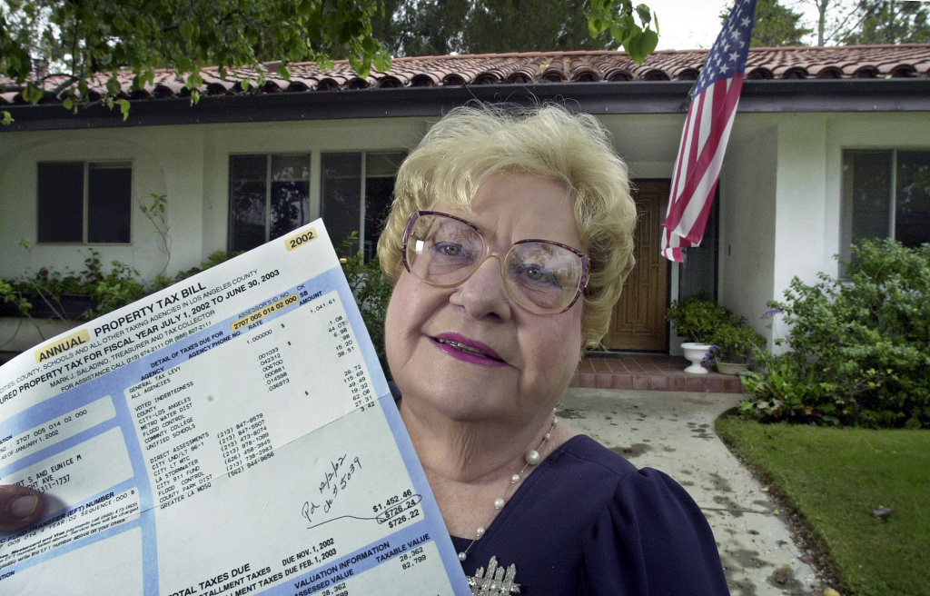 TOUGH CHOICES CAUSES Eunice McTyre, one of the original activist proponents of the 1978 California tax-limitation initiative Proposition 13, poses in front of her home with her current property tax bill, in the Chatsworth area of Los Angeles Thursday, Feb. 13, 2003.