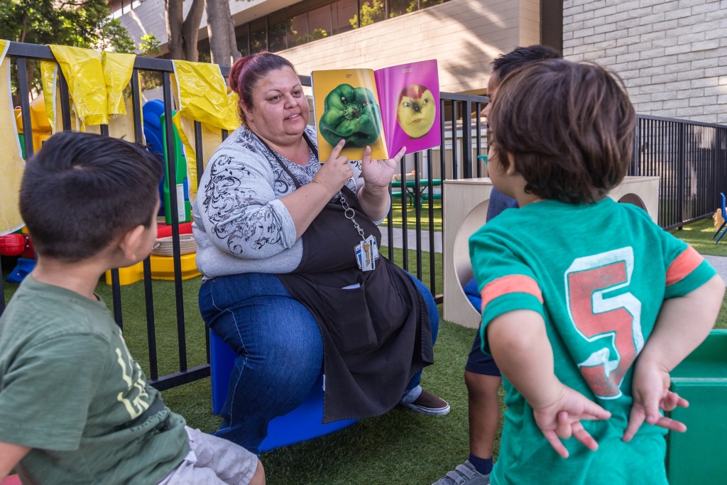 Apprenticeship program Rosa Lopez reads a book to kids at the Mexican American Opportunity Fund child care center in Norwalk. She's been in the child care field for 24 years and makes under $15/hr.