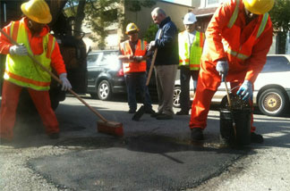Mercer 13269 Los Angeles street services crew members Joyce Robinson and Ralph Jackson repair a pothole on Reno Street