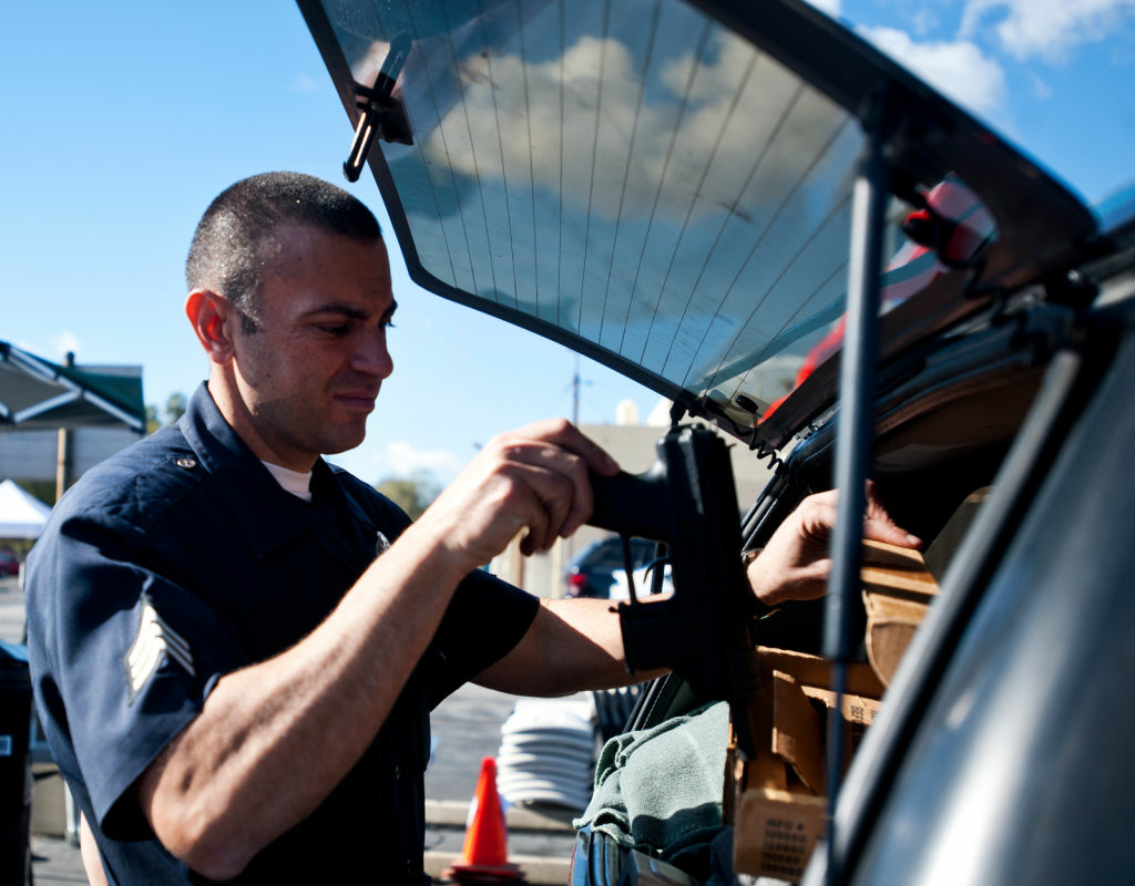 LAPD Sgt. Ishmail receives a TEC-9 semi-automatic handgun. A range of assault weapons, including M-16's, Uzi's, and MAC-11's, were turned in during a recent gun buyback program.