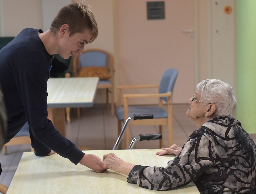 FRANCE-HEALTH-EDUCATION-ALZHEIMER A teenager holds the hand of a woman with Alzheimer's disease in a retirement home on October 18, 2016 in Saint Quirin, France.