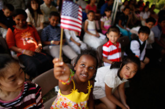 Six-year-old Rahel Williams holds up a United States flag during a ceremony where she and 24 other children became U.S. citizens at the Sully Historic Site in Chantilly, Virginia in May. (Photo by Chip Somodevilla/Getty Images)