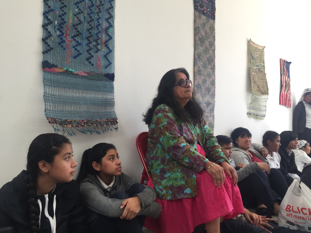 Fiber artist Consuelo Jimenez Underwood listens as students from Clinton Middle present the flowers they made for an exhibition. Fiber artist Consuelo Jimenez Underwood listens as students from Clinton Middle present the flowers they made for an exhibition.