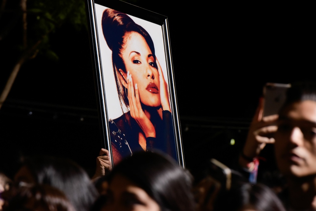 US-ENTERTAINMENT-MUSIC-HWOF-SELENA A fan holds a photo of Selena during the ceremony honoring singer Selena Quintanilla with a star on the Hollywood Walk of Fame on November 3, 2017.