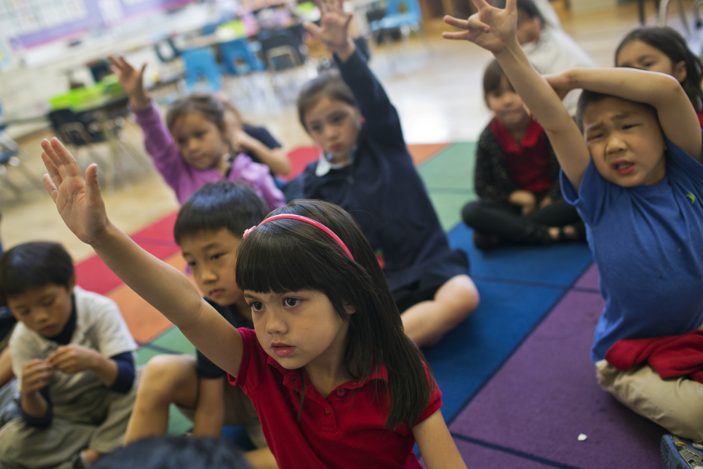 Mandarin Immersion - 6 Kindergartener Mimi Echavez raises her hand to answer a question as teacher Tingting Mei reads a book to students at Eugene Field Elementary, a Mandarin immersion school in Pasadena, on Thursday morning, May 28, 2015.