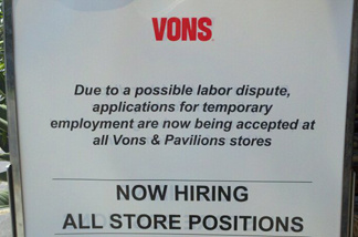 A sign outside of a Vons supermarket calls for applications for temporary employment.