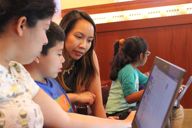 Children’s librarian Brooke Sheets (center) uses colored cups to teach algorithms and debugging to a group of girls at a computer science fair at L.A.'s downtown Central Library