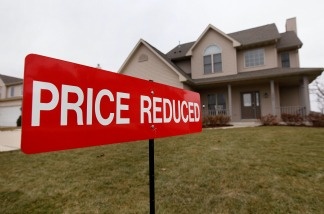 Mercer 12373 A sign sits in the front yard of a home being offered for sale in Pleasant Prairie, Wisconsin. The Case-Shiller index shows housing prices dropped in March to their lowest point since the housing bubble burst in 2006.