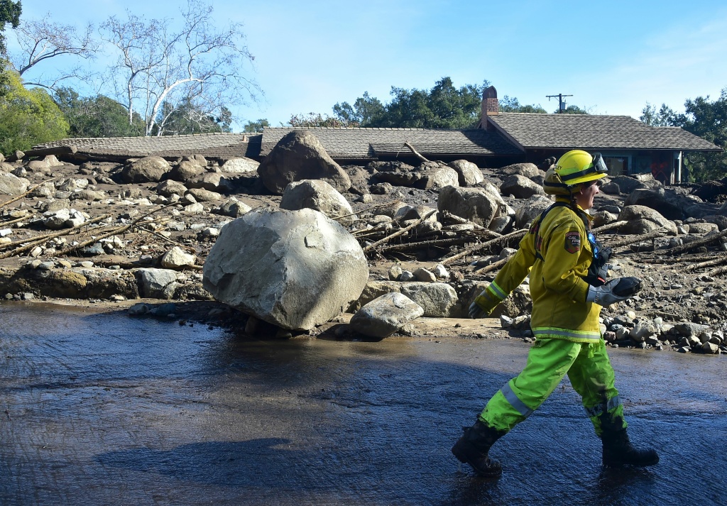 US-WEATHER-MUDSLIDES A rescue worker walks past debris near a property in Montecito, California January 12, 2018.