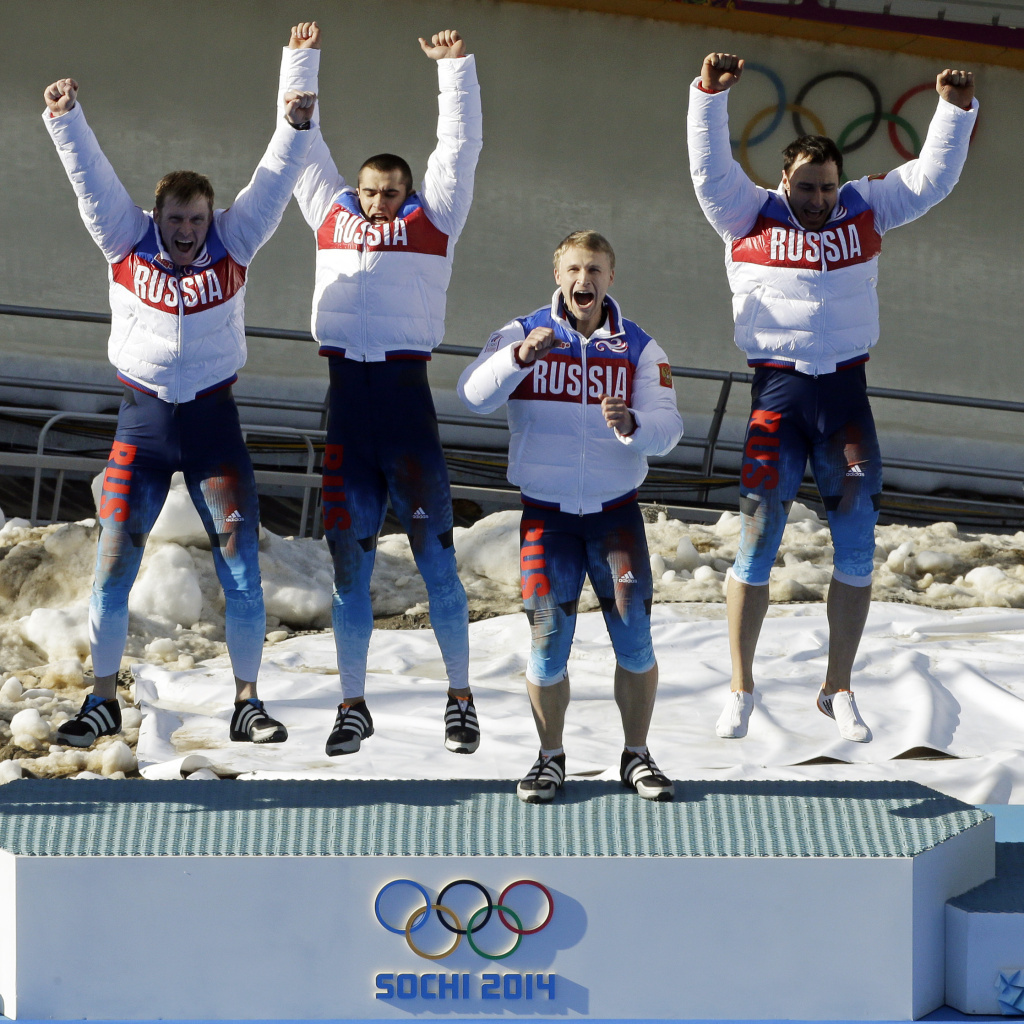 Russia RUS-1 bobsled team, with Alexander Zubkov, Alexey Negodaylo, Dmitry Trunenkov, and Alexey Voevoda, jump onto the medal stand after winning gold on Sunday. On the last day of the Sochi Games, Russia had already secured the top spot in the overall medal count.