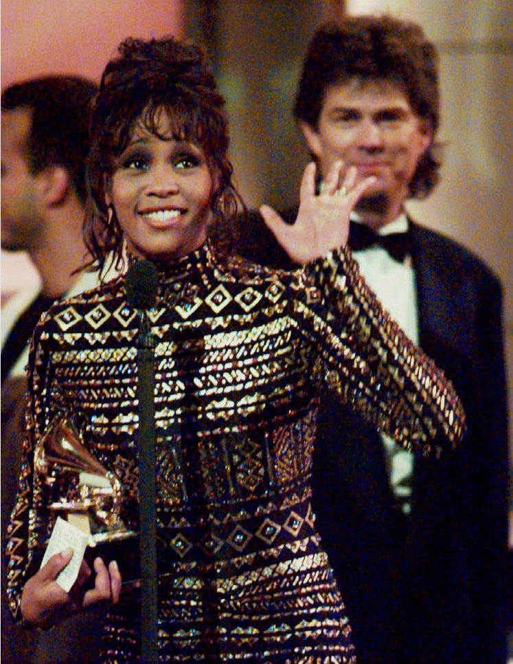 Whitney Houston waves to the crowd at the 36th Annual Grammy Awards in New York 01 March 1994 after she was honored for Record of the Year, 'I'll Always Love You,' and Album of the Year, the soundtrack from the film 'The Bodyguard.'