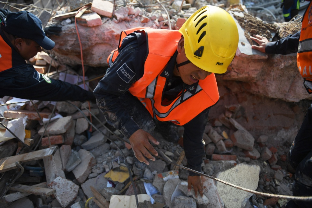 MEXICO-QUAKE A member of the Federal Police's rescue team searches for survivors in Juchitan de Zaragoza, Mexico, on September 9, 2017 after a powerful earthquake struck Mexico's Pacific coast.