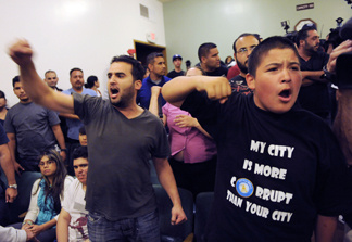 Bell, Calif. residents Hussein Saleh, left, and Eddie Delgado call for the ouster of city officials during a special meeting of the Bell City Council, Thursday, July 22, 2010, in Bell, Calif. Bell's police chief and two top city administrators agreed to resign Thursday night during a closed-door meeting at City Hall. Revelations about Bell city leaders' pay has sparked anger in a blue-collar town that is one of the poorest in Los Angeles County.
