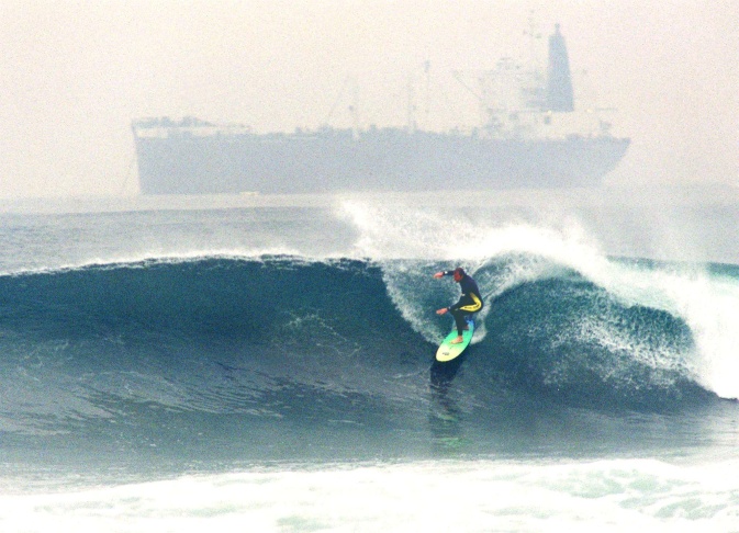 1938: People walk along the flooded L.A. River near the Dayton Avenue Bridge. In the background, a railroad bridge hangs in a twisted heap after one of the pilings has collapsed. (Photograph courtesy of the Los Angeles Public Library)