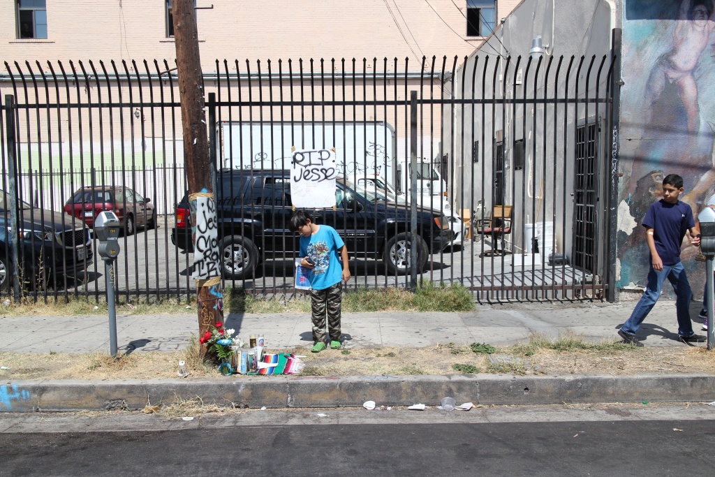 Boyle Heights OIS A boy stands over the memorial for 14-year-old Jesse Romero, who was shot and killed by police in Boyle Heights on Aug. 9.