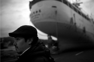 Ship owner Yuta Suzuki and one of his grounded vessels that was thrown on shore during the tsunami in Kesennuma, Miyagi prefecture.