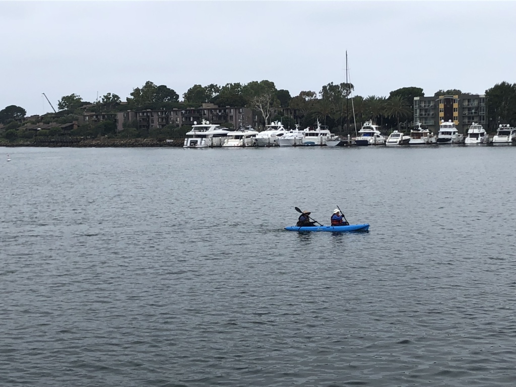 Two kayakers paddle through Marina Del Rey's main channel. Two kayakers paddle through Marina Del Rey's main channel.