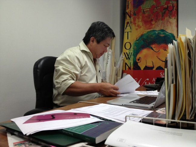 Chinatown residents wait for the bus outside the site of a new neighborhood market from Walmart on the edge of Chinatown at Grand and Cesar Chavez avenues.
