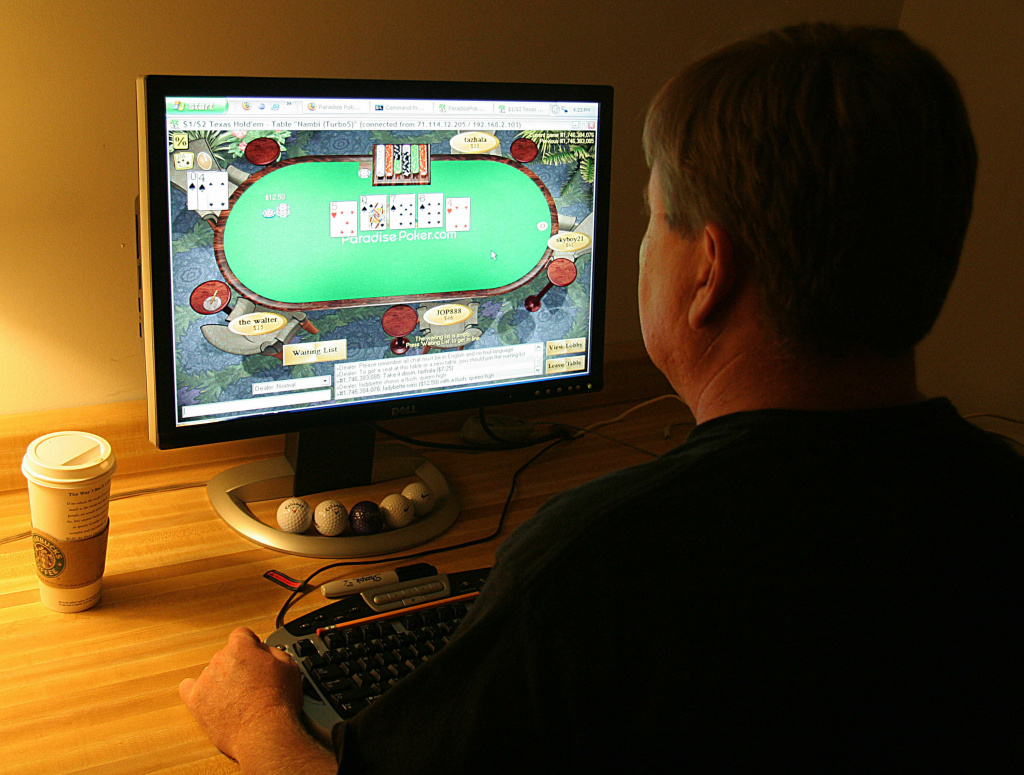 A man plays poker on his computer connec A man plays poker on his computer connected to an internet gaming site from his home in Manassas, VA 02 October, 2006.