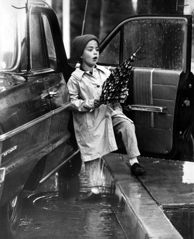 1938: People walk along the flooded L.A. River near the Dayton Avenue Bridge. In the background, a railroad bridge hangs in a twisted heap after one of the pilings has collapsed. (Photograph courtesy of the Los Angeles Public Library)