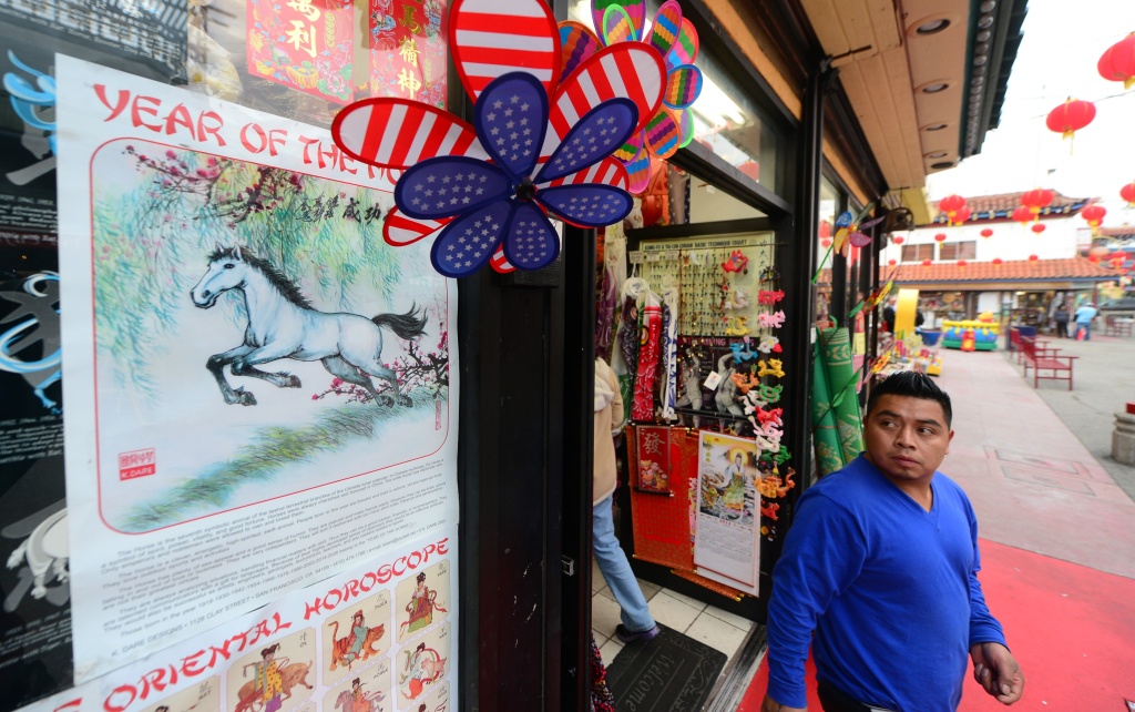 US-FESTIVAL-LUNAR-NEW YEAR A man steps out of a shop selling curios and trinkets looking toward a Year of the Horse on the shopfront window in Chinatown's Central Plaza in Los Angeles on January 30, 2014, on the eve of the Year of the Horse, or 4712 in the Chinese Calendar.