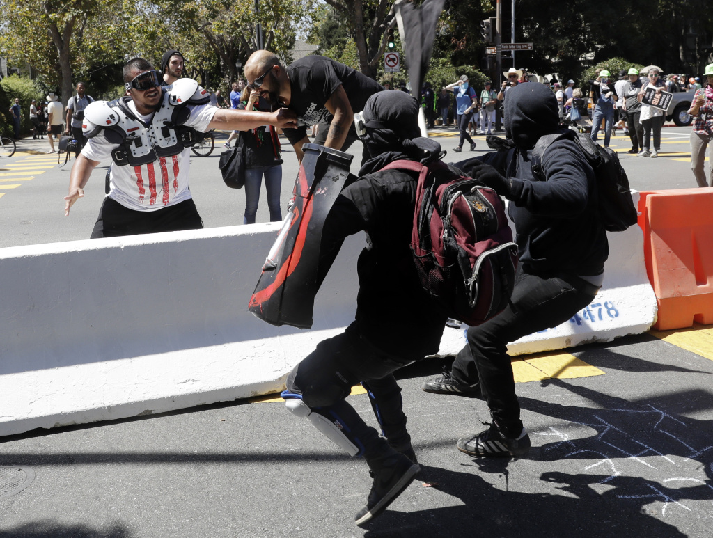 Demonstrator Joey Gibson, second from left, is chased by anti-fascists during a free speech rally Sunday, Aug. 27, 2017, in Berkeley, Calif. Several thousand people converged in Berkeley Sunday for a "Rally Against Hate" in response to a planned right-wing protest that raised concerns of violence and triggered a massive police presence. Several people were arrested for violating rules against covering their faces or carrying items banned by authorities.