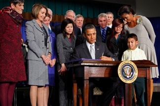 President Barack Obama signs the Healthy, Hunger-Free Kids Act of 2010 with Rep. Rosa DeLauro (D-Conn., left), Speaker Nancy Pelosi (D-Calif., second from left), first lady Michelle Obama (right), third-grader Luis Avilar-Turcios (second from right) and seventh-grader Tammy Nguyen (third from right) at Harriet Tubman Elementary School on Dec. 13, 2010 in Washington, D.C. In an effort to provide children with better school lunches and breakfasts, the new law puts $4.5 billion in the hands of child nutrition programs, sets nutrition standards on school vending machines, helps create school gardens and makes sure that quality drinking water is available during meal times.